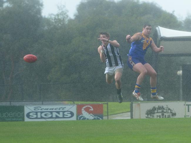 Narre Warren Robert Dierickx and Cranbourne’s Luke Martin get airborne in the driving rain. Picture: Susan Windmiller