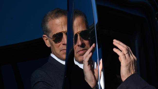 A reflection on the side of a vehicle shows Hunter Biden, son of US President Joe Biden, stepping into a car upon arrival at Fort Lesley J. McNair in Washington, DC, on July 1, 2024. Hunter Biden was travelling with his father who returned to Washington for the first time after the first presidential debate in Atlanta on June 27. (Photo by Mandel NGAN / AFP)