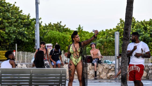 A woman takes a selfie as she drinks with her friends at Miami Beach, Florida on June 26. Young adults in Florida are fueling a dangerous rise in COVID-19 infections.