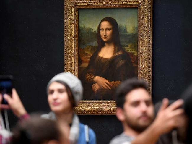 Visitors take pictures in frront of Mona Lisa after it was returned at its place at the Louvre Museum in Paris on October 7, 2019. - Leonardo da Vinci's masterpiece, the "Mona Lisa," returned to her usual spot in Paris' Louvre Museum on October 7 following a two-month renovation for the gallery housing the world's most famous painting. (Photo by ERIC FEFERBERG / AFP)