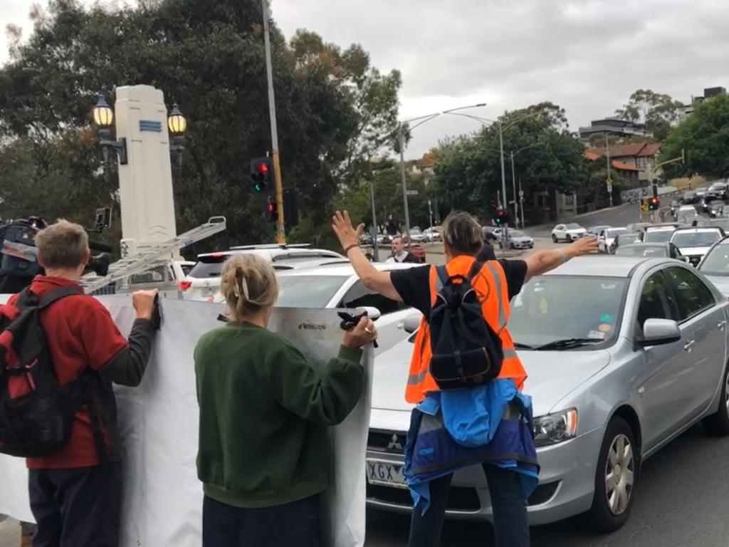 Extinction Rebellion hold a "slow march" protest rally on an arterial road during peak our in Melbourne.