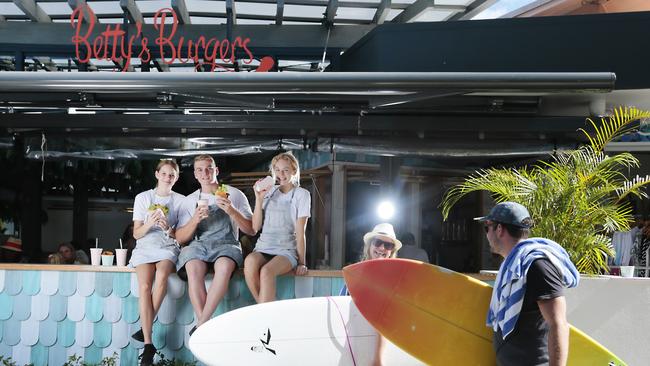 Bettys Burgers staff Phoebe Cooney, Jamie O'Brien and Julia Johnson take a break at the go to burger bar on Hastings Street in Noosa. Picture: Lachie Millard