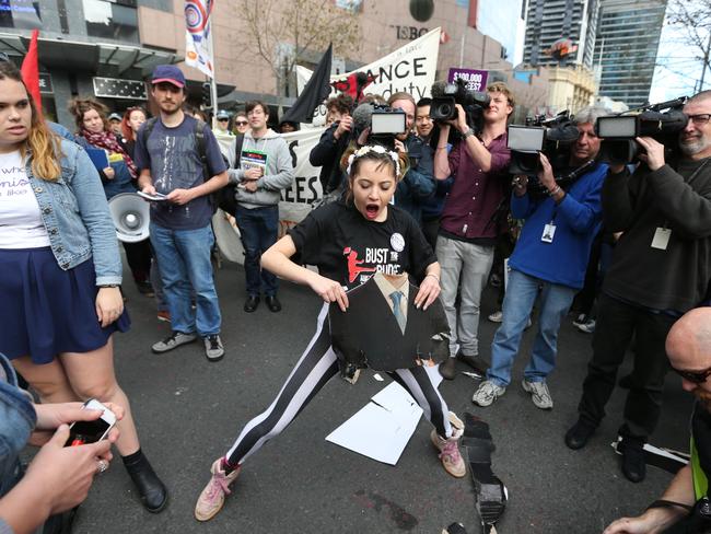 A cardboard cut out of MP Christopher Pyne is set on fire and then stomped on by protesters marching against fee changes.