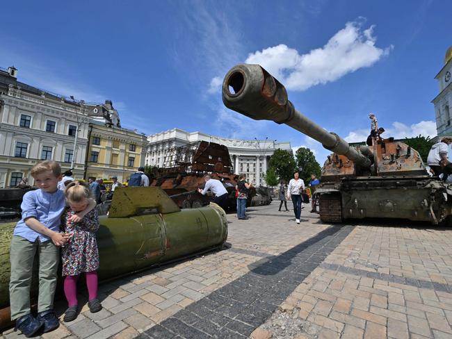 Two children sit on a fragment of a Russian rocket.