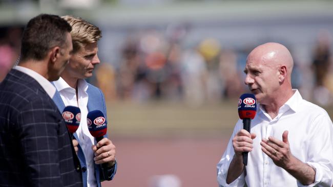 Former Tasmanian Premier Peter Gutwein speaks to Nick Riewoldt and Alastair Lynch during a game.