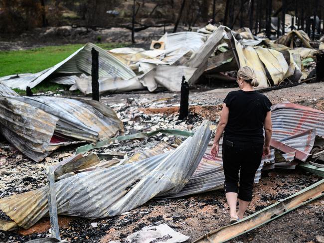 Averill Berryman looking at the remains of her Real Estate and Dog Grooming businesses, which were both destroyed by the New Year’s Eve bush fire, in Mogo. Picture: James Gourley