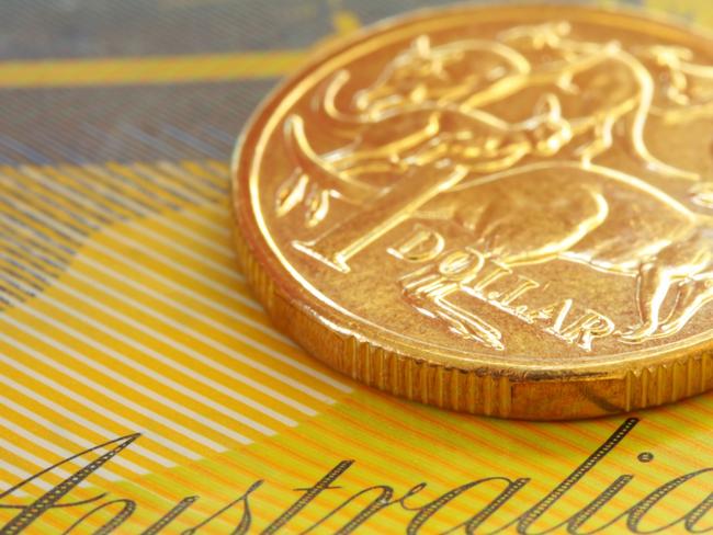 Australian one dollar coin on a fifty dollar note.  Close-up view, with shallow depth of field; generic money