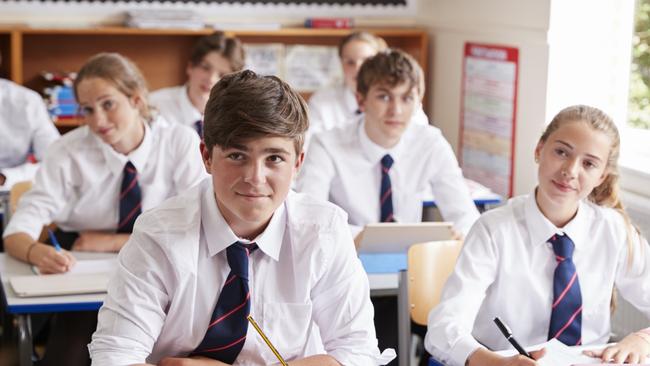 Students Listening To Female Teacher In Classroom