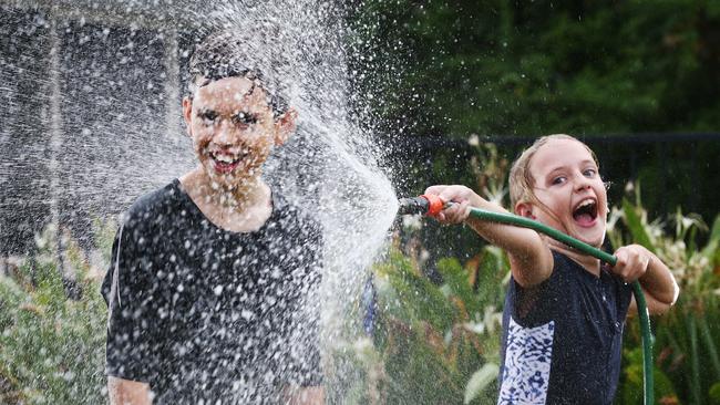 Stella Sattler, 8, and her brother Scott, 10, cool off from the heatwave conditions. PICTURE: BRENDAN RADKE