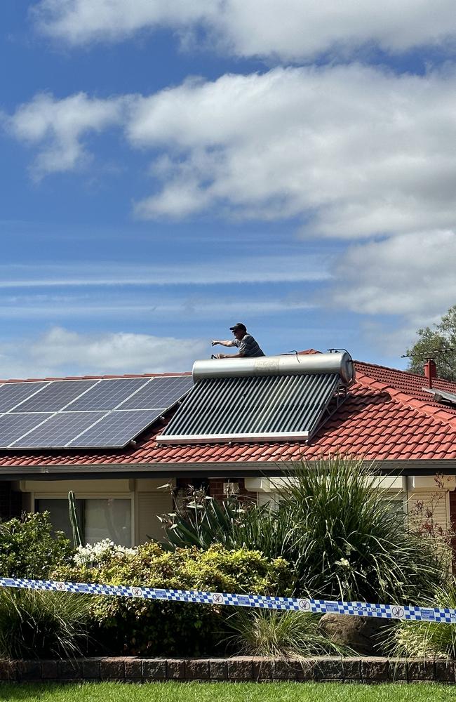 Sam Laiosa inspects the damage to his roof.