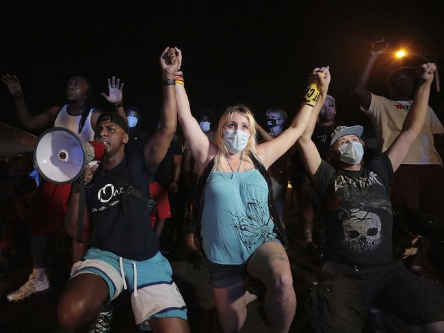 Protesters locked hands and knelt while blocking Union Avenue as they rally over the death of George Floyd in Memphis. Picture: AP