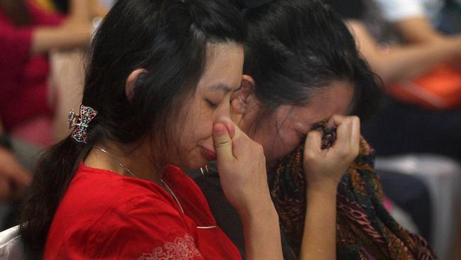 Relatives and next-of-kin of passengers on the AirAsia flight QZ8501 wait prayerfully for the latest news on the search of the missing jetliner at Juanda International Airport in Surabaya, East Java, Indonesia. Pic: AP Photo/Trisnadi Marjan.