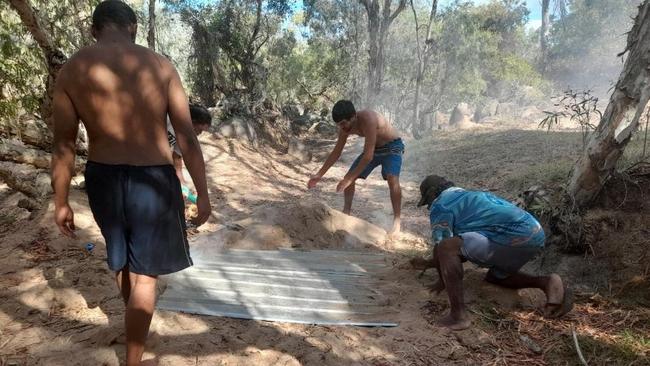 Joseph Callope shows young Indigenous men how to cook in the traditional practice of Kup Murri. Picture: supplied