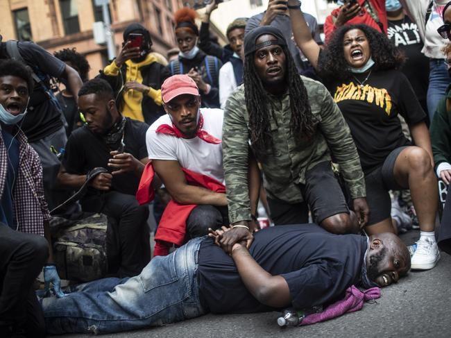 Protesters reenact the scene where George Floyd was restrained by police while marching in a solidarity rally calling for justice over the death of George Floyd Tuesday, June 2, 2020, in New York. Floyd died after being restrained by Minneapolis police officers on May 25. (AP Photo/Wong Maye-E)