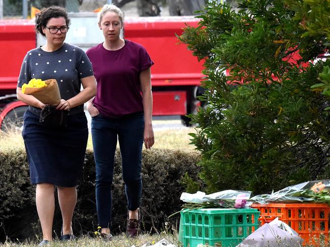 Two women lay flower tributes. Picture: Nicole Garmston