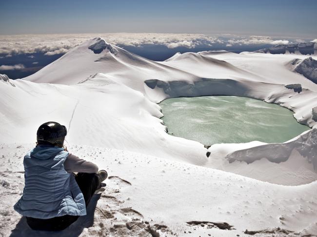 A climber looking out to the crater lake of Mt Ruapehu and beyond.