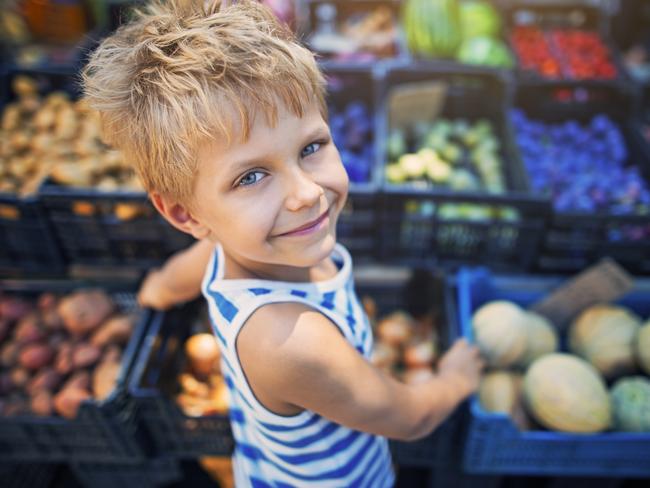 Happy little boy buying local groceries food at the tuscanian farmer's market at Cecina. Italy, Tuscany.  iStock generic markets shopping