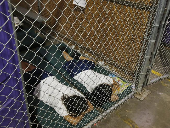 Two female detainees sleep in a holding cell, as the children are separated by age group and gender, as hundreds of immigrant children are being held at the US Customs and Border Protection Nogales Placement Center in Nogales, Arizona. Picture: AP Photo/Ross D. Franklin