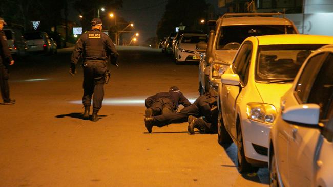 Officers search the street for evidence. Picture: Damian Hoffman