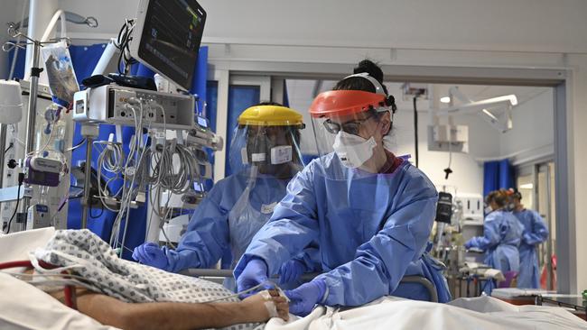 Members of the clinical staff wearing Personal Protective Equipment PPE care for a patient with coronavirus in the intensive care unit at the Royal Papworth Hospital in Cambridge, England.