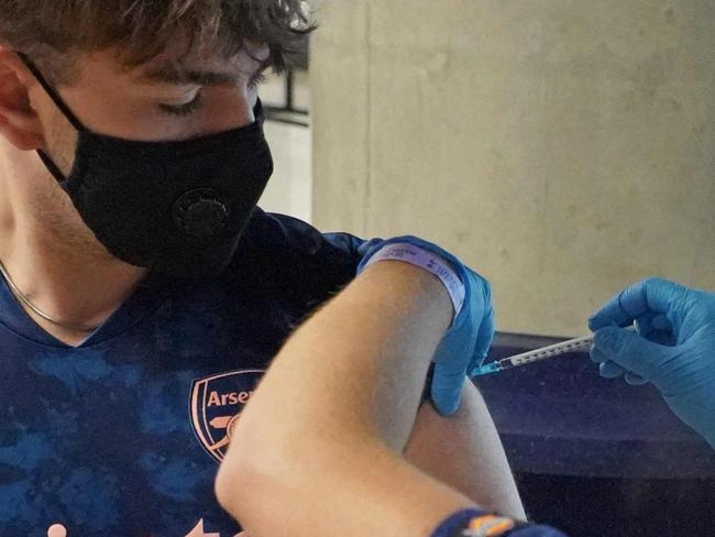 18-year-old Solomon Bird receives a dose of the Pfizer/BioNTech covid-19 vaccine at a vaccination centre set up at Premier League club Tottenham Hotspur's football stadium in London on June 20, 2021. - As the UK opens Covid-19 vaccination appointments to all over 18s, Tottenham Hotspur has opened its stadium as a vaccination centre, with 3,000 people booked in on its day of operation, Sunday 20 June, with space for thousands more walk-in appointments. (Photo by Will EDWARDS / AFP)