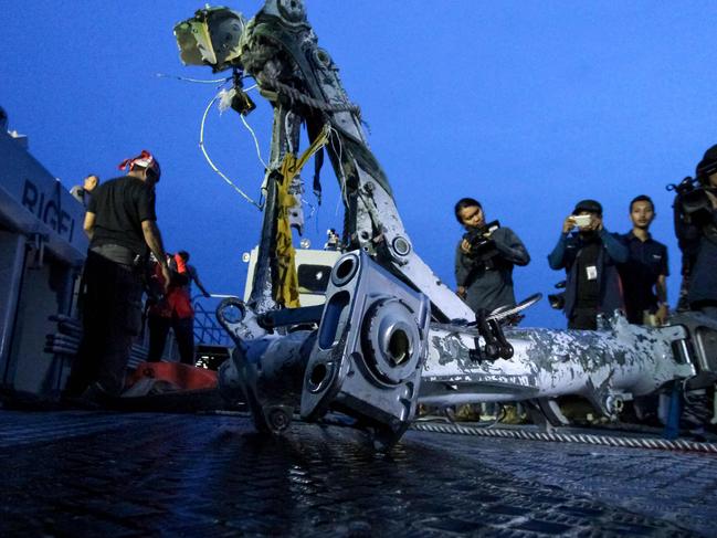 Members of the search team lift part of the landing gear of the ill-fated Lion Air flight JT 610 during search operations at sea off the coast from Karawang. Picture: AFP