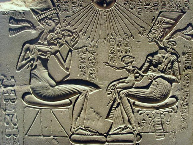 Pharoah Akhenaten, left, depicted with his chief wife Nefertiti (here wearing the crown of a pharaoh), right, playing with several of their daughters.