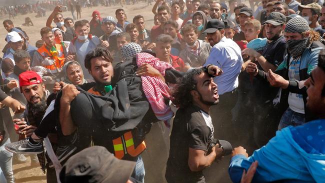 Palestinians carry a demonstrator injured during clashes with Israeli forces. Picture: AFP