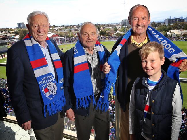 1954 Bulldogs premiership players Angus Abbey, Doug Reynolds and Ron Stockman, with grandson Shaun, during the Western Bulldogs training session at Whitten Oval. Picture: Hamish Blair