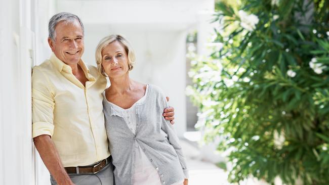 Sunday Mail, Looking Forward - Portrait of an older couple posing for the camera in front of their house with copy space; Senior homeowner couples at home, mortgage, generic