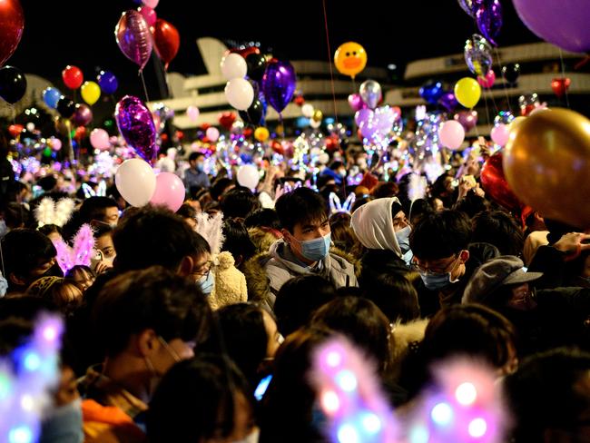 People wearing face masks attend a New Year's countdown in Wuhan.