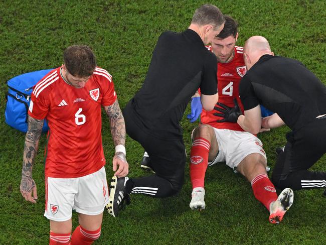 Wales' defender #04 Ben Davies (2nd R) receives medical attention after his header went wrong. Picture: Antonin Thuillier/AFP