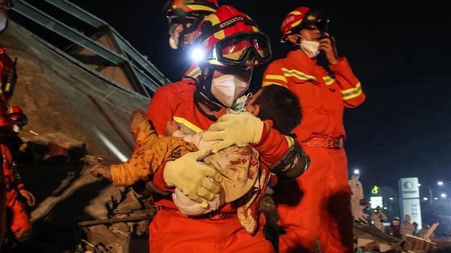 A boy is rescued from the rubble of the collapsed hotel in Quanzhou. Picture: AFP.