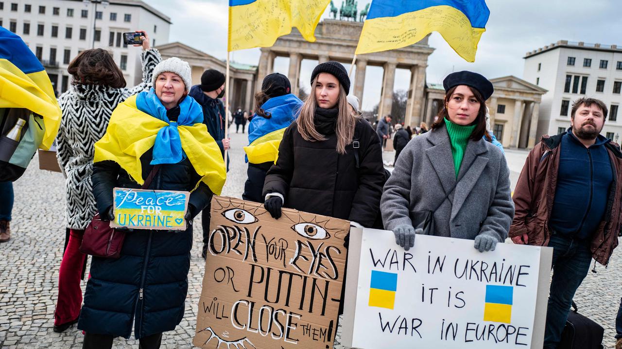 Demonstrators display placards criticising Russian President Vladimir Putin during a protest at Berlin's Brandenburg Gate on January 30. Picture: John MacDougall/AFP