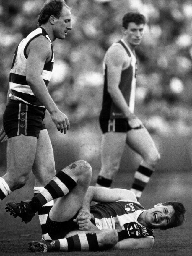 Cats champion Gary Ablett looks on as Frawley writhes in agony, Geelong v St Kilda, 1990.