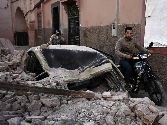 A man rides a motorcycle past the rubble in the old quarters of Marrakesh on September 10, 2023, two days after a devastating 6.8-magnitude earthquake. Picture: AFP