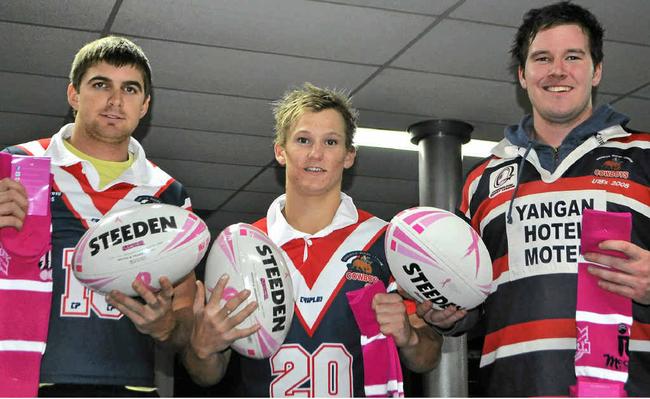 Cowboys players Hayden McNicol, Trent Achilles and Ryan Kinlyside with the pink socks and special edition footballs for today’s game. Picture: Erin Smith