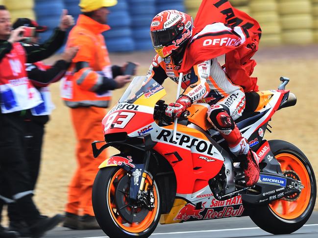 Repsol Honda Team's Spanish rider Marc Marquez rides with his team flag after his victory.