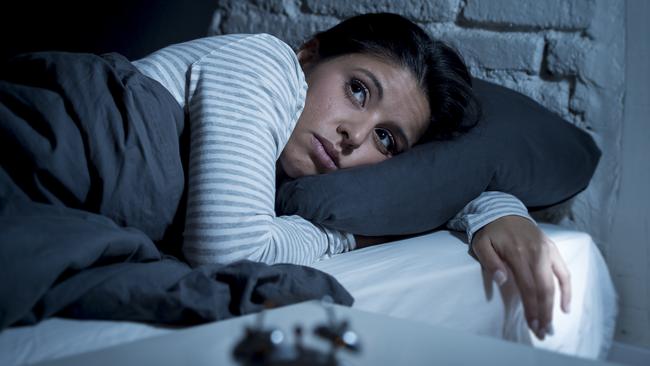 young beautiful hispanic woman at home bedroom lying in bed late at night trying to sleep suffering insomnia sleeping disorder or scared on nightmares looking sad worried and stressed