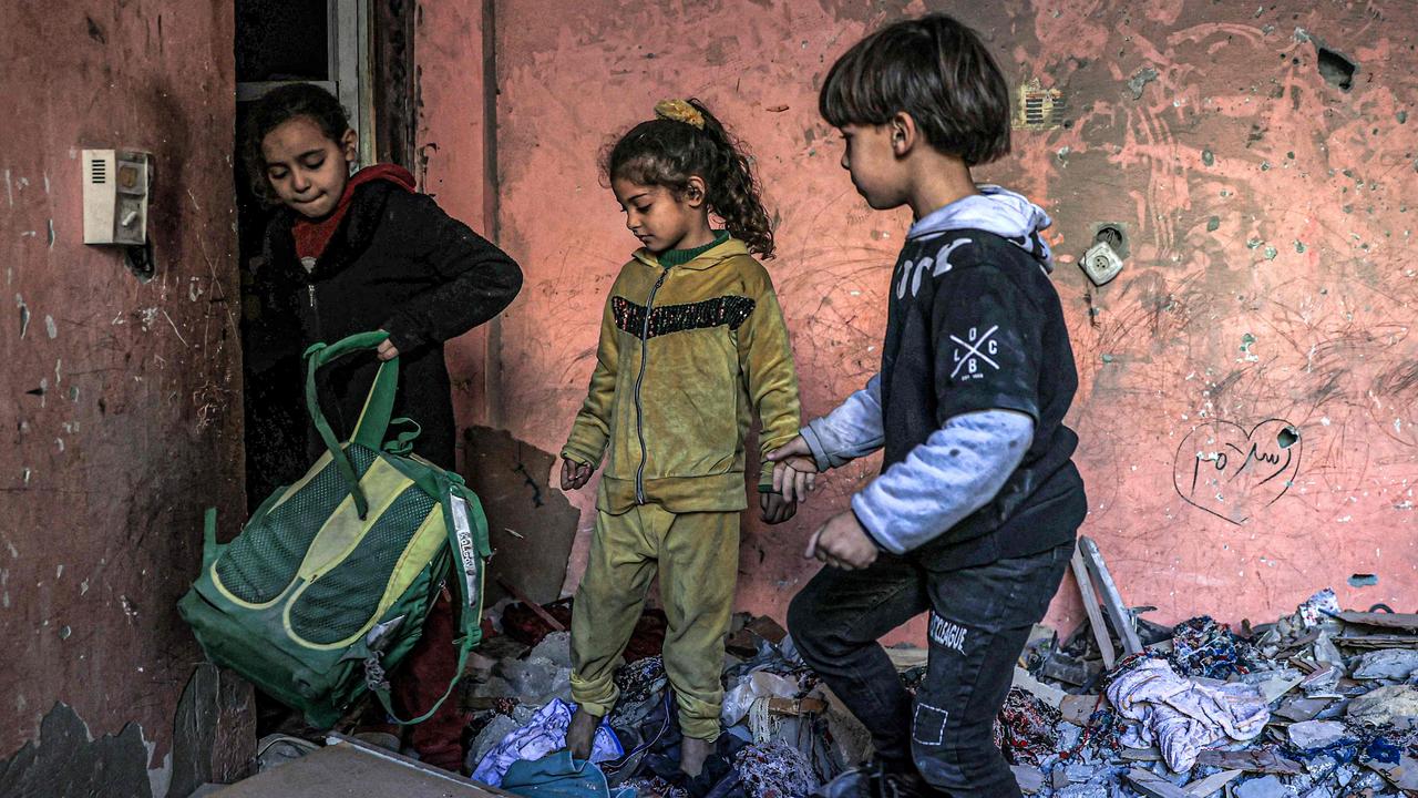 Children search through the rubble of a building in Rafah, which had been largely destroyed by Israeli bombardment. Picture: Said Khatib/AFP