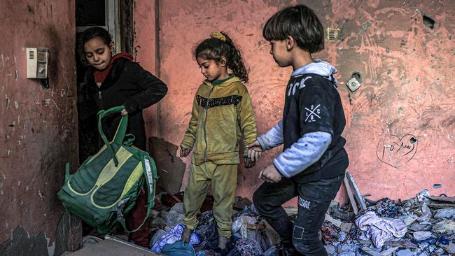 Children search through the rubble of a building in Rafah, which had been largely destroyed by Israeli bombardment. Picture: Said Khatib/AFP