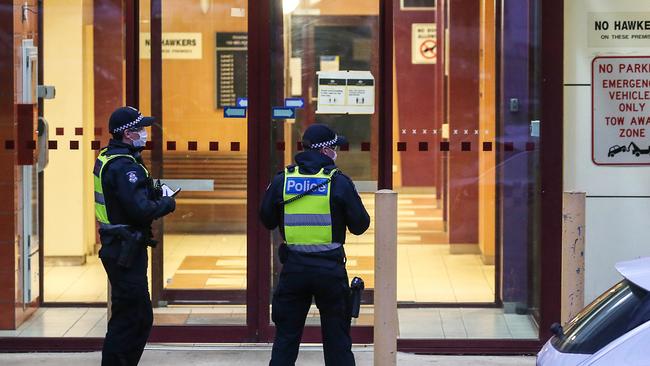 Police guard an entrance to one of the locked-down public housing estates. Picture: Ian Currie