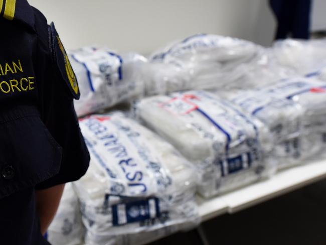 Victorian Police, Australian Federal Police and Australian Border Force officers stand in front of approximately 275 kilograms of crystal methamphetamine on display at the Australian Federal Police offices in Melbourne, Monday, July, 4, 2016. A Victoria Joint Organised Crime Task Force (JOCTF) seized the methamphetamine with a street value of $275 million after identifying the syndicate in February, arresting one Malaysian and seven Australians. This is the biggest seizure in Victoria this year. (AAP Image/Tracey Nearmy) NO ARCHIVING