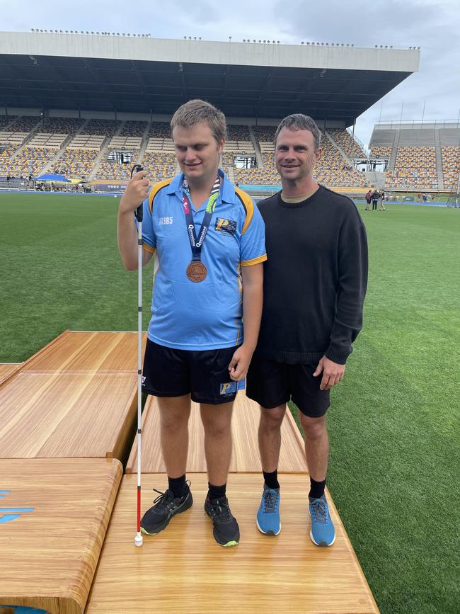 Peninsula's Riley Beazley with his father Jonno after Riley claimed a bronze medal in the vision impaired category.