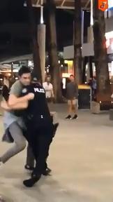 The moment a Gold Coast police officer is body slammed in Surfers Paradise