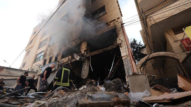 Palestinian firefighters survey damaged stores following an Israeli military raid on the Jenin Palestinian refugee camp, in Jenin in the occupied northern West Bank. Picture: AFP