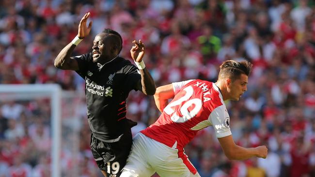 Granit Xhaka (R) challenges Liverpool's Senegalese midfielder Sadio Mane (L).