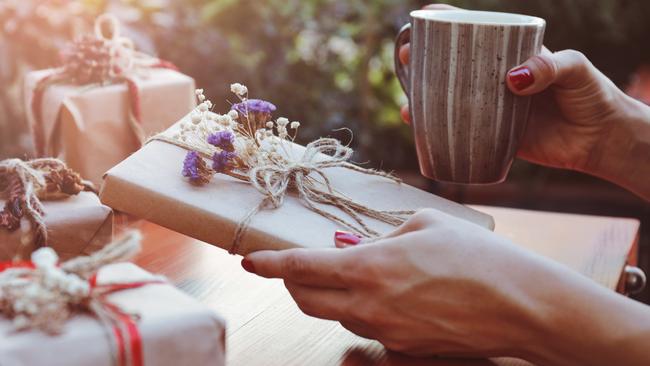 A woman looking at beautifully wrapped gifts. Picture: iStock