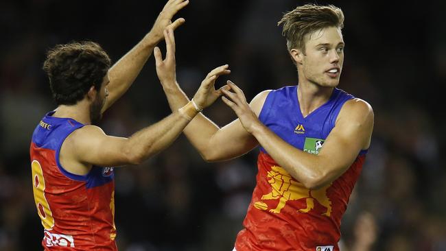 Brisbane forward Josch Schache (right) celebrates a goal.