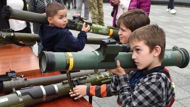 Children get the heads around some military hardware in Lviv. Picture: AFP